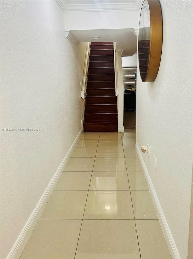 hall featuring ornamental molding and tile patterned floors