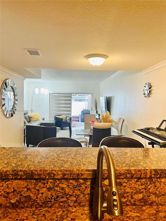 kitchen with ornamental molding and a textured ceiling