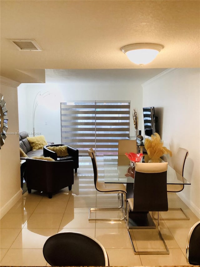 tiled dining area featuring a textured ceiling and crown molding