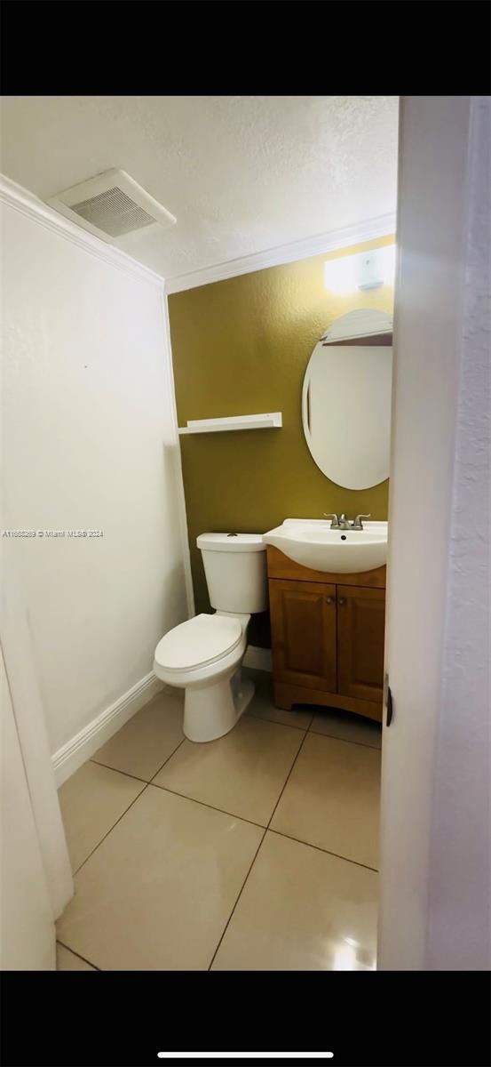 bathroom featuring ornamental molding, vanity, tile patterned flooring, and toilet