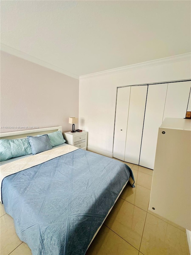 tiled bedroom featuring a closet and crown molding