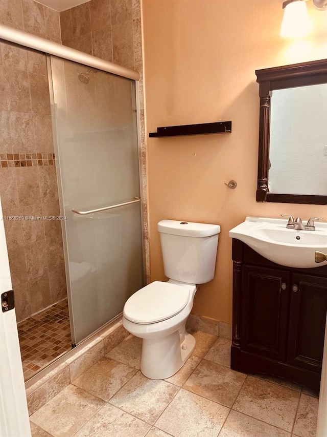 bathroom with an enclosed shower, vanity, and toilet