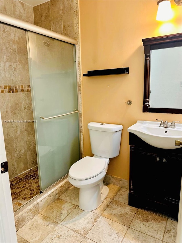 bathroom featuring vanity, toilet, and an enclosed shower