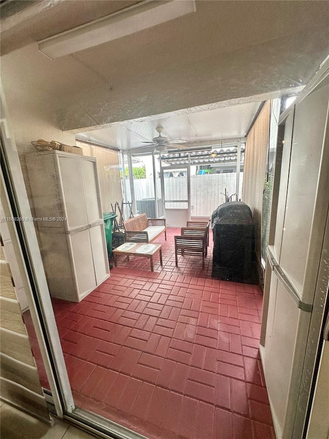 unfurnished sunroom with ceiling fan