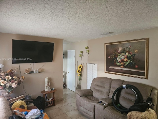 tiled living room featuring a textured ceiling