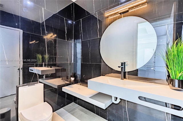 bathroom with toilet, tile walls, and tile patterned flooring