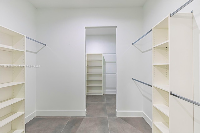 walk in closet with dark tile patterned floors