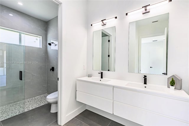 bathroom with toilet, walk in shower, vanity, and tile patterned flooring