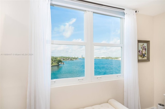 bedroom featuring multiple windows and a water view