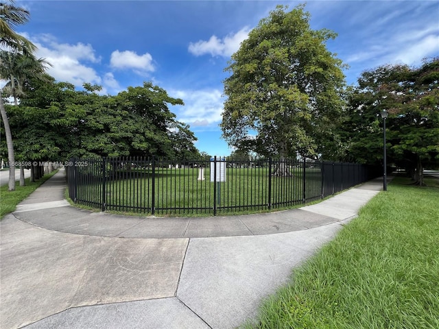 surrounding community with a lawn and a fenced front yard