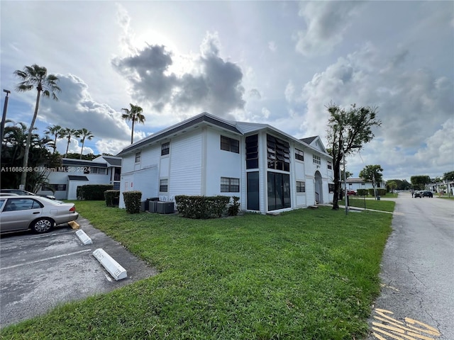 view of side of property featuring a sunroom and a yard