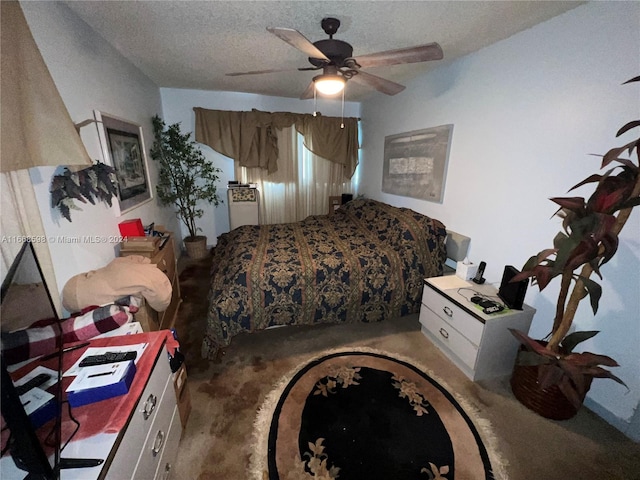 carpeted bedroom featuring ceiling fan and a textured ceiling