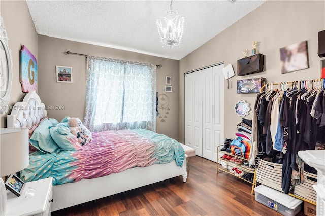 bedroom featuring a closet, a textured ceiling, dark hardwood / wood-style floors, a notable chandelier, and lofted ceiling