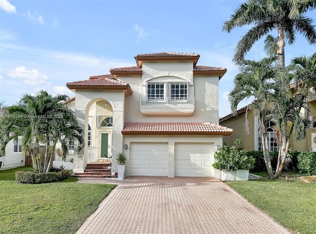 mediterranean / spanish-style home with decorative driveway, a front yard, and stucco siding