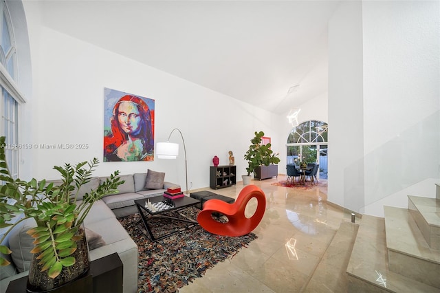 living area featuring marble finish floor and high vaulted ceiling