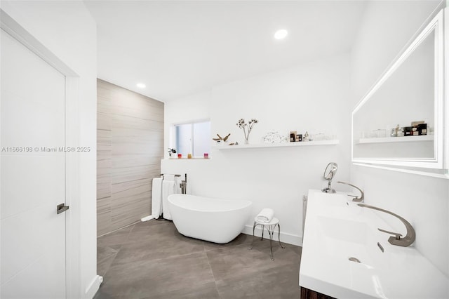 full bath with recessed lighting, a soaking tub, a sink, and double vanity