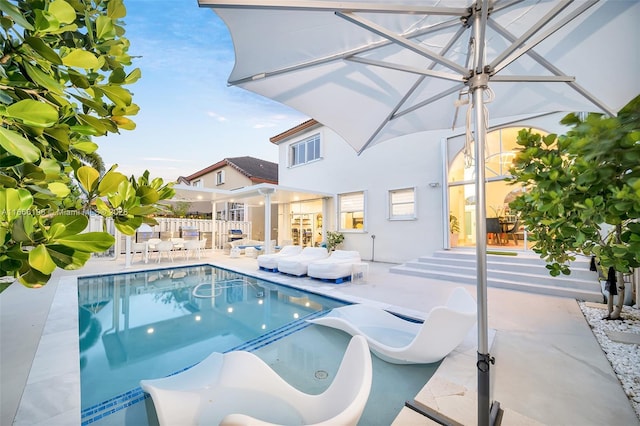 outdoor pool with a patio area and fence