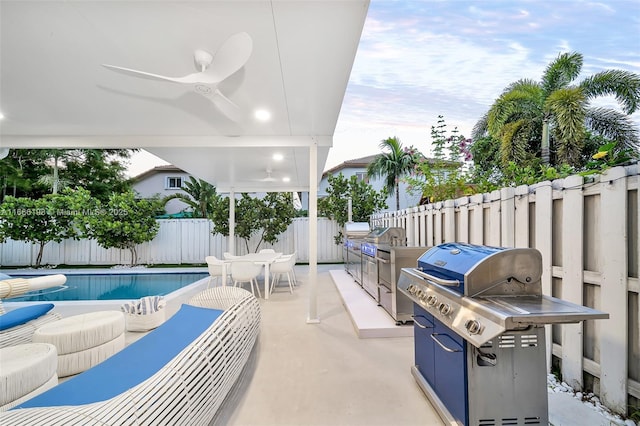 view of patio / terrace with ceiling fan, an outdoor kitchen, a fenced backyard, grilling area, and a fenced in pool