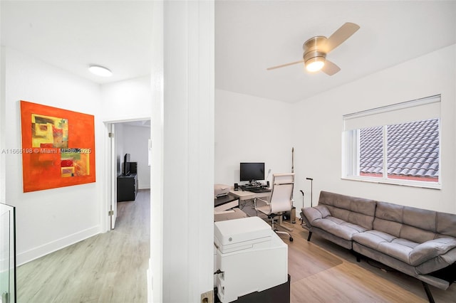 living area featuring light wood-type flooring, ceiling fan, and baseboards