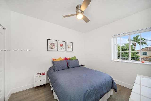 bedroom featuring a ceiling fan, baseboards, and dark wood-style flooring