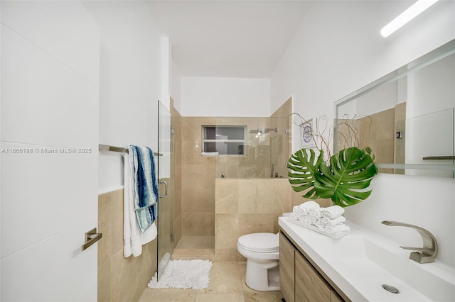 full bathroom featuring toilet, a shower stall, tile walls, and vanity