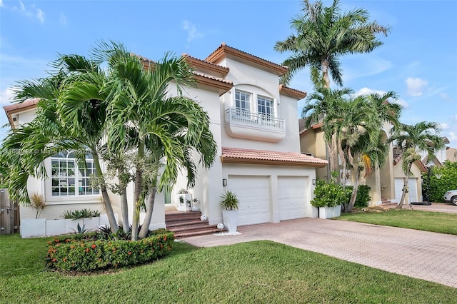 mediterranean / spanish-style house with an attached garage, decorative driveway, and stucco siding