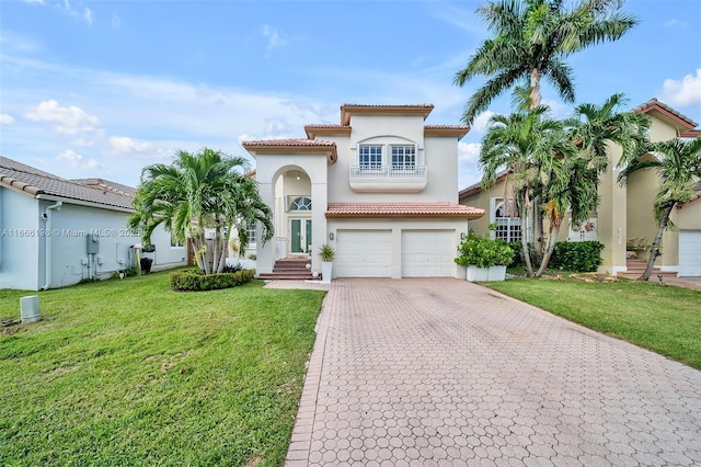 mediterranean / spanish home with a garage, a front lawn, decorative driveway, and stucco siding