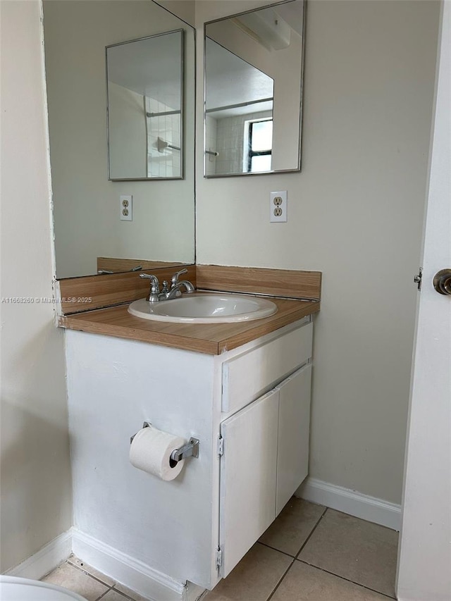 bathroom with tile patterned flooring, vanity, and baseboards