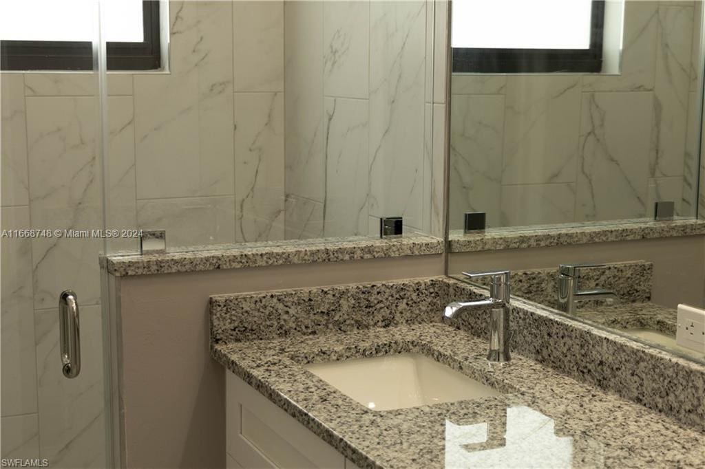 bathroom featuring vanity and a shower with shower door