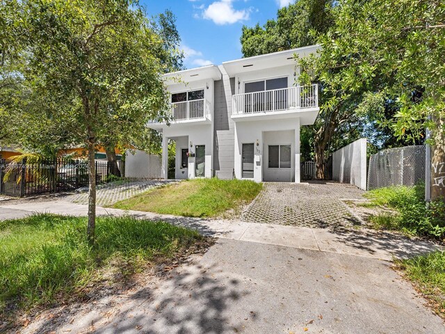 163 NW 68th Ter, Miami, FL 33150 - view of front facade featuring a balcony, driveway, and stucco siding