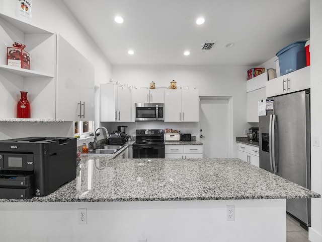 kitchen with white cabinets, sink, stainless steel appliances, and kitchen peninsula