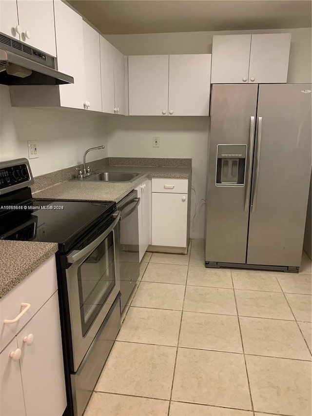 kitchen with white cabinets, light tile patterned flooring, appliances with stainless steel finishes, and sink