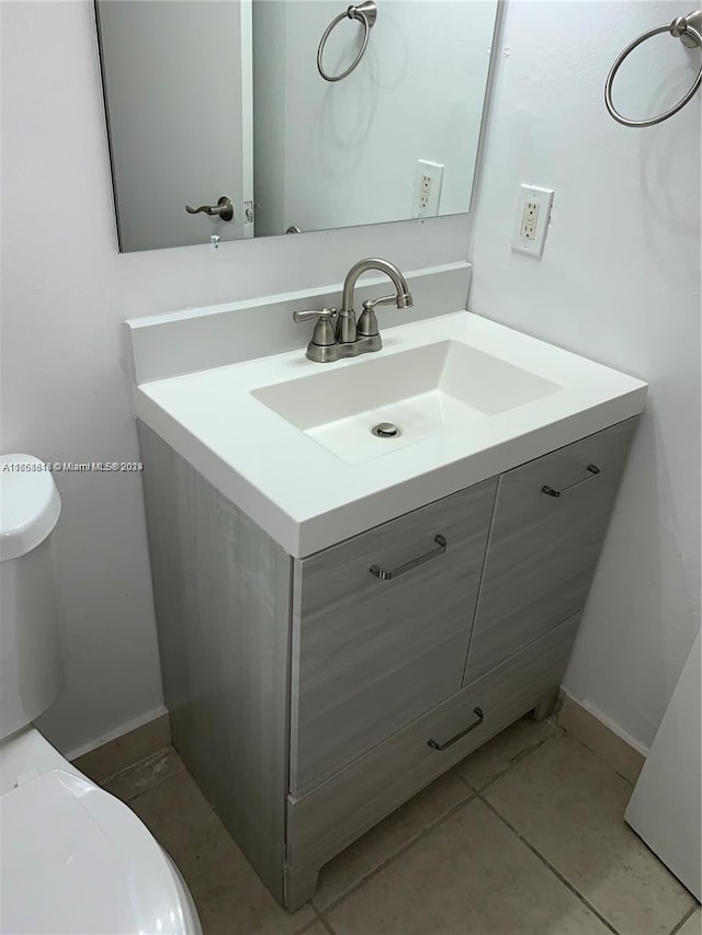 bathroom with tile patterned flooring, vanity, and toilet