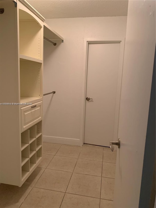 walk in closet featuring light tile patterned flooring