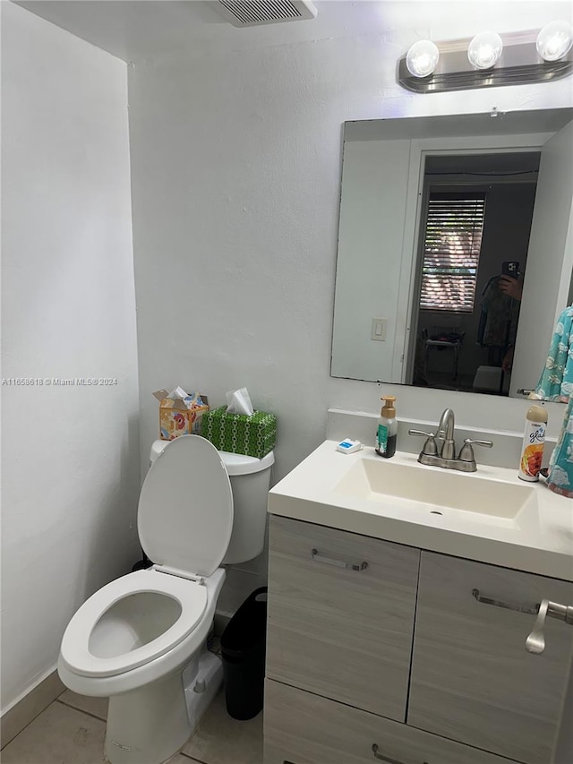 bathroom featuring tile patterned floors, vanity, and toilet