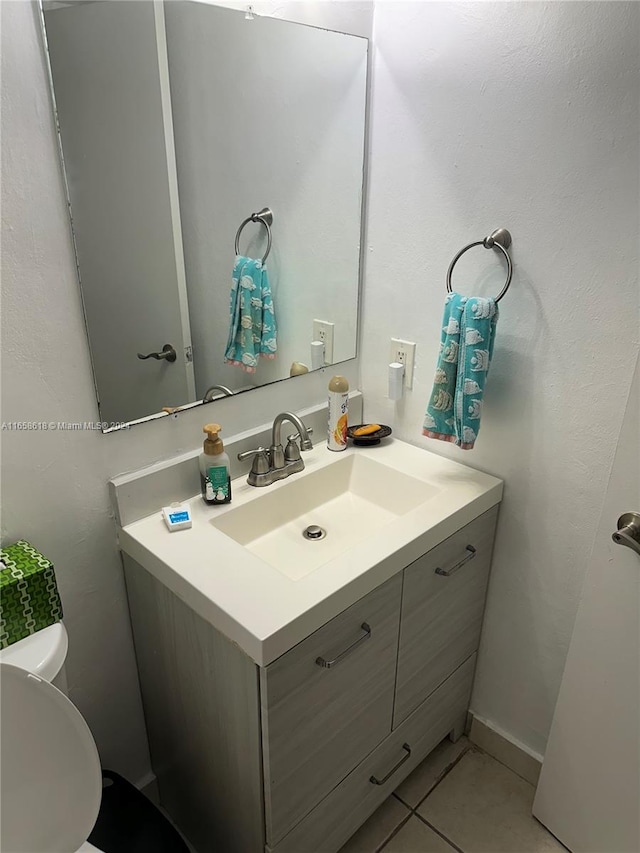 bathroom featuring tile patterned floors, vanity, and toilet