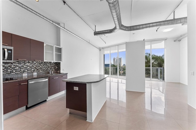 kitchen with dark brown cabinets, light tile patterned floors, appliances with stainless steel finishes, and tasteful backsplash