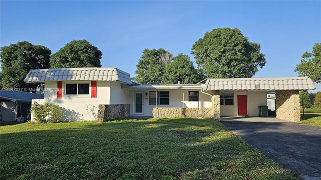 view of front of home with a front lawn and a carport