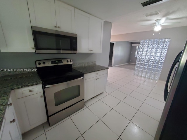 kitchen featuring white cabinetry, appliances with stainless steel finishes, and dark stone countertops