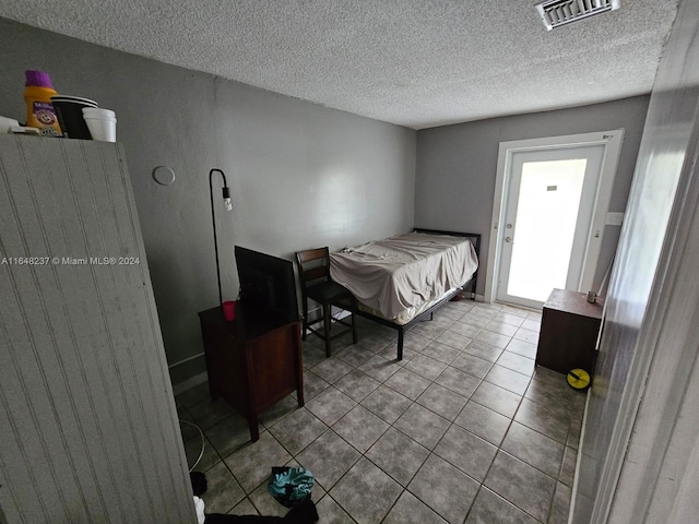 tiled bedroom with a textured ceiling