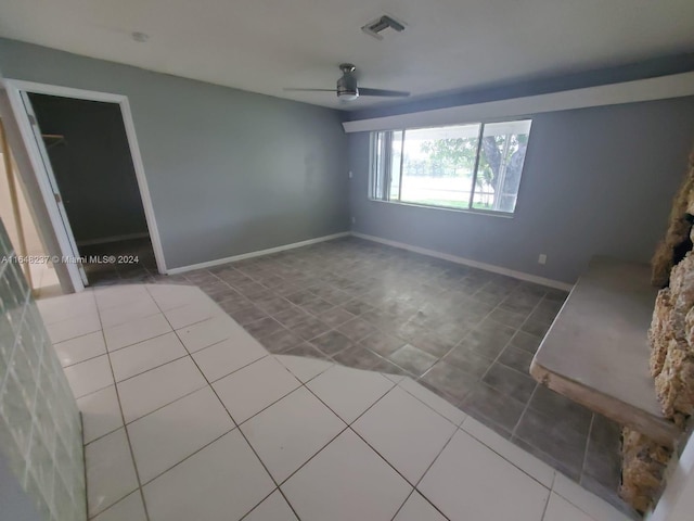 tiled empty room with ceiling fan