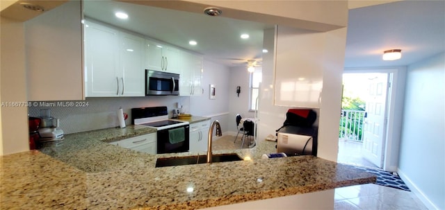 kitchen featuring ceiling fan, white cabinetry, a healthy amount of sunlight, and white range with electric stovetop