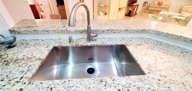 room details featuring light stone countertops and sink