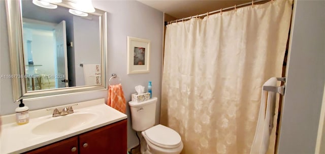 bathroom featuring a shower with curtain, vanity, and toilet