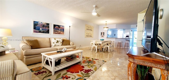 living room with ceiling fan and a textured ceiling