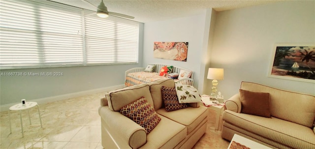 living room with a textured ceiling, light tile patterned floors, and ceiling fan