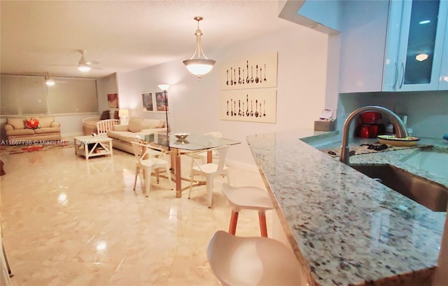 dining space with ceiling fan and sink