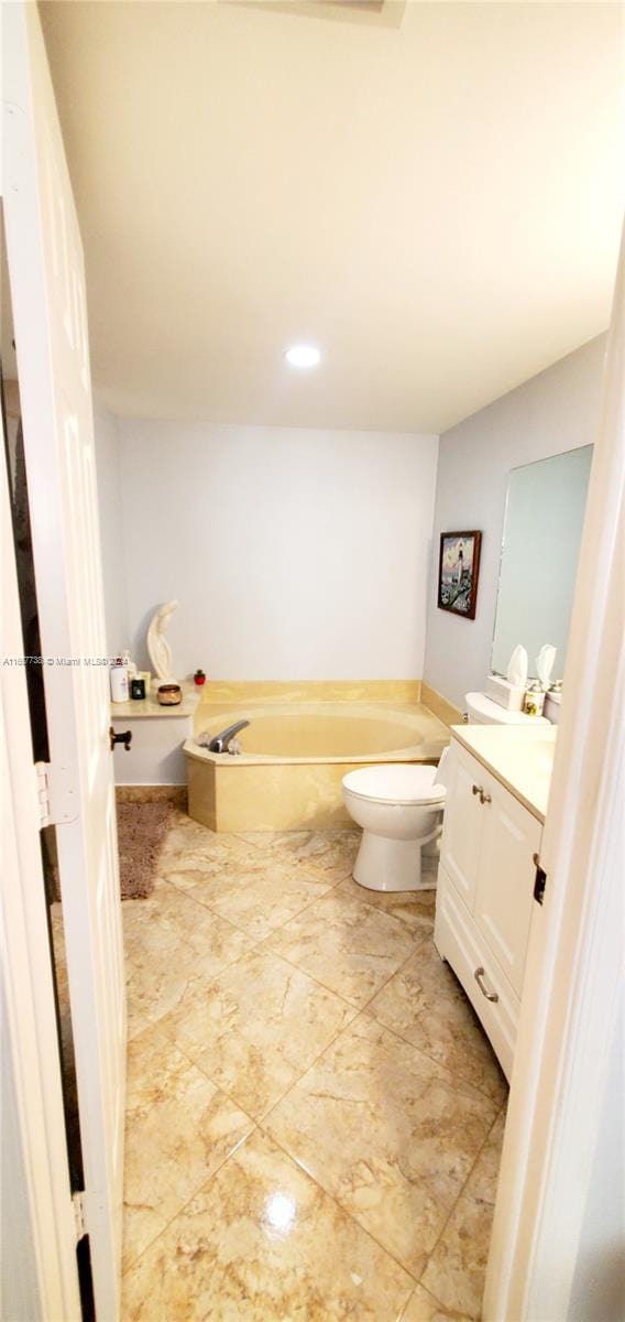 bathroom featuring a bath, vanity, and toilet