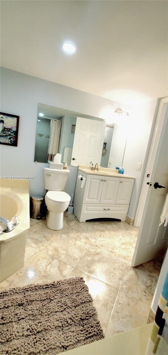 bathroom featuring vanity, a bathtub, and toilet