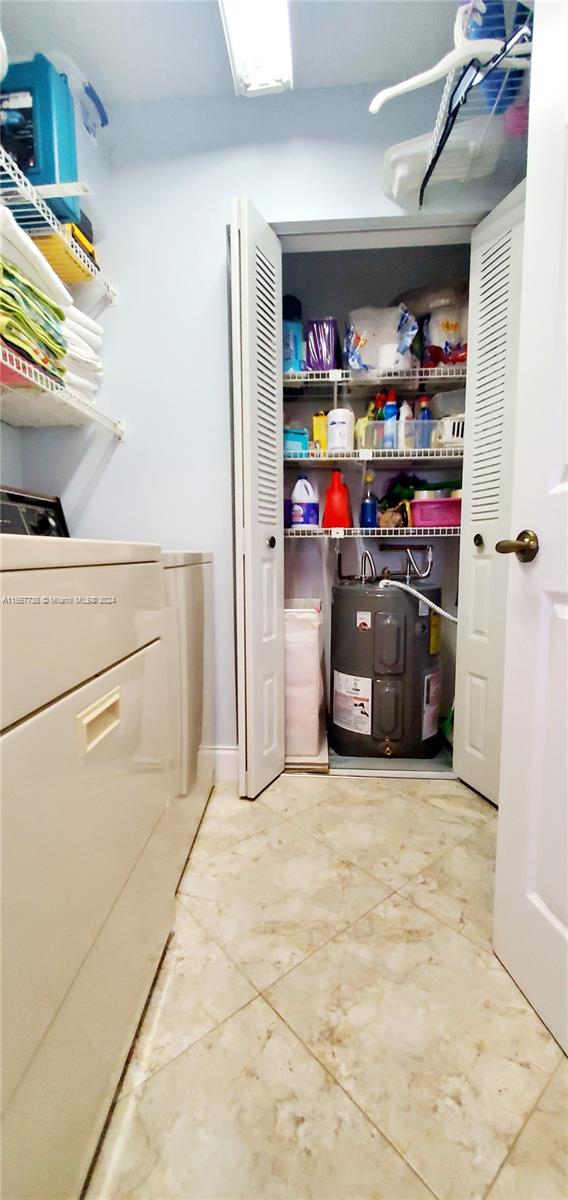 clothes washing area featuring water heater